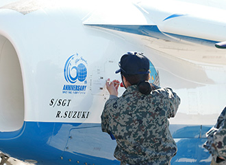 担当する機体に「R.SUZUKI」の文字がレタリングされているのが見える。「S/SGT」は「staff sergeant＝3等空曹」を意味する。一つの機体全体を担当する「機付長」が鈴木氏の役職である。