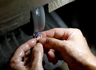 すべての釉薬を盛った指輪を砥石で慎重に磨いていく。最も熟練の技を必要とする工程だ